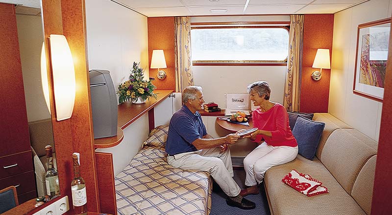 Couple chatting inside standard stateroom