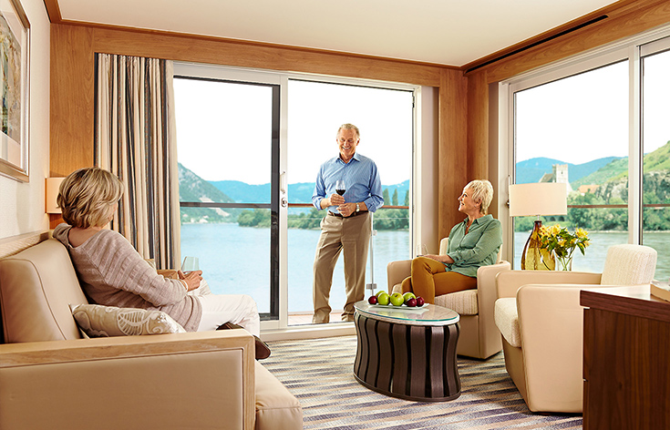 Three people socializing in a living area of a Viking stateroom