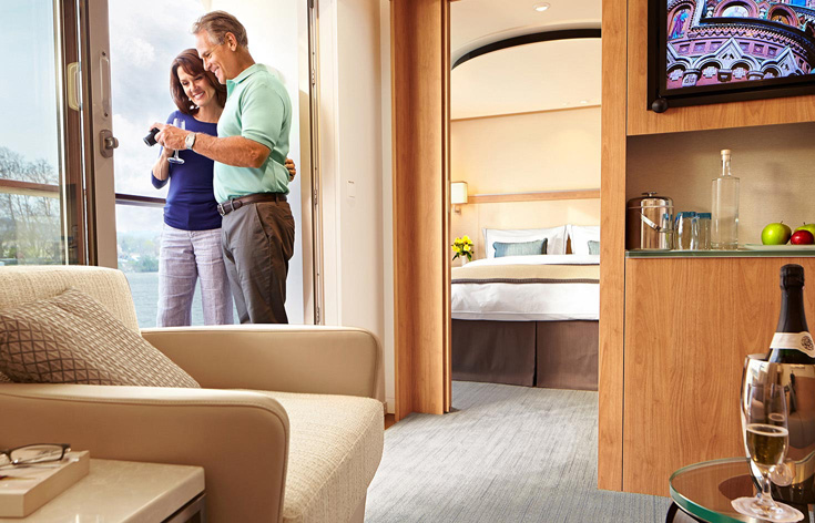 A couple viewing photos in a Viking stateroom